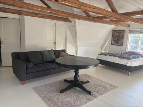 a living room with a couch and a table and a bed at Kopperhemmets Gård in Holmared