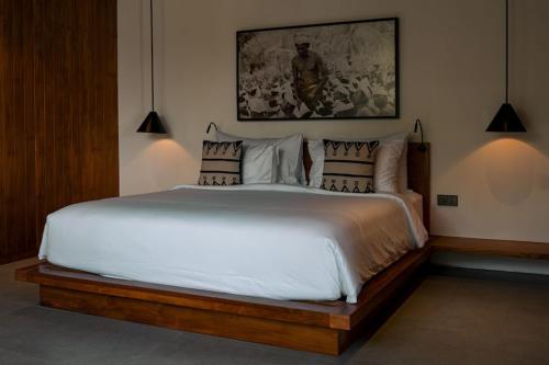 a bedroom with a large white bed with pillows at Angel's Villa & Resort in Selong