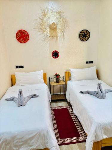 two beds in a room with stuffed animals on them at my Surfhouse in Imsouane
