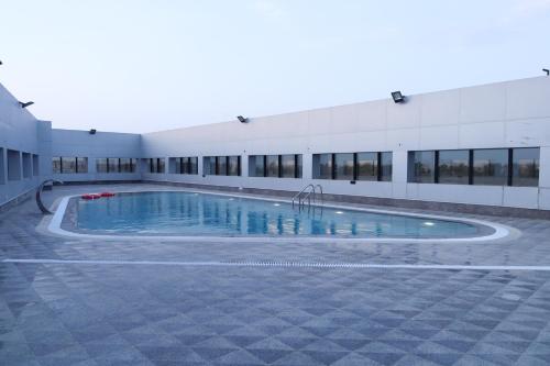 a building with a swimming pool in front of a building at Best Day Hotel and Resorts المحمدية in Jeddah