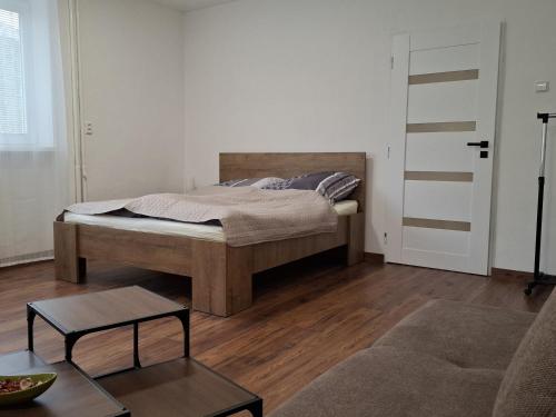 a bedroom with a bed and a living room at Apartmán pri Gaderskej bráne in Blatnica