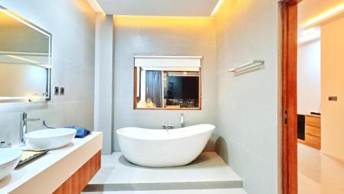a bathroom with a large tub and two sinks at Angel's Villa & Resort in Selong