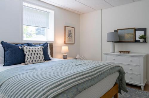 a bedroom with a bed with blue pillows and a window at Beachwood of Narragansett in Narragansett