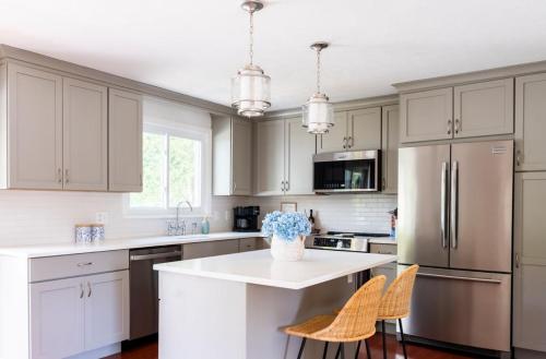 a kitchen with white cabinets and a white counter top at Beachwood of Narragansett in Narragansett