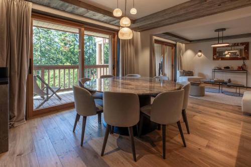 ein Esszimmer mit Glastisch und Stühlen in der Unterkunft Antares Ursa 201 in Méribel