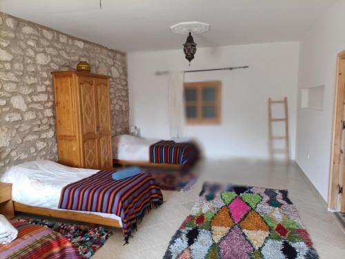 a bedroom with a bed and a chair and a rug at Villa Dar Albatros Great for groups surf, yoga, friends and family in Sidi Kouaki