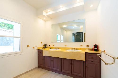 Un baño con dos lavabos y un espejo grande. en Domaine Royal, en Nimes