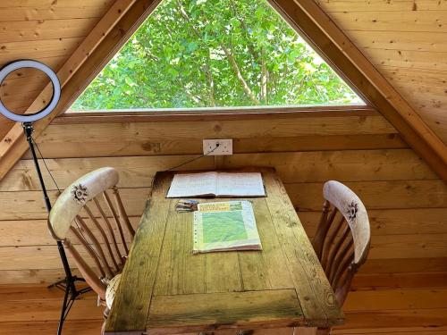 a wooden table in a room with a window at Sauna, Hot Tub & Cold Plunge Pyramid Escape in Lindridge