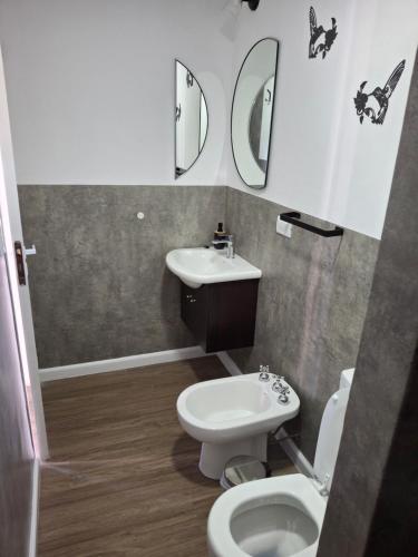 La salle de bains est pourvue de toilettes, d'un lavabo et d'un miroir. dans l'établissement Ecos de Mar Refugios, à Puerto Pirámides