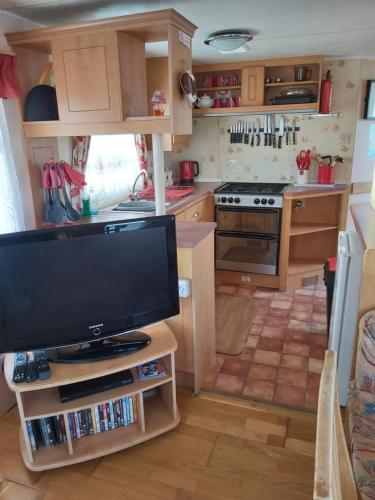 a kitchen with a flat screen tv in a kitchen at The grange caravan park ingoldmells in Addlethorpe
