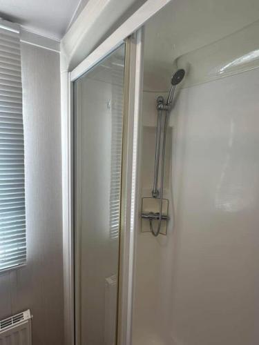 a shower in a bathroom with a mirror at Seaview Lodgings in Dunure