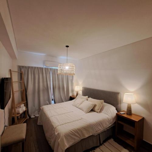 a bedroom with a bed and a chandelier at Apart entre viñas in Cafayate