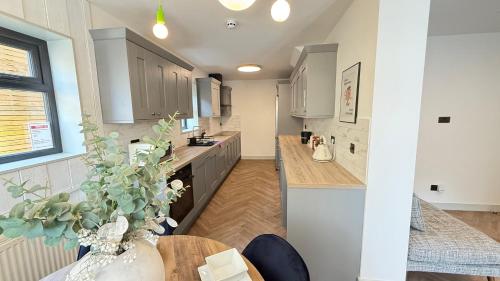 a kitchen with white cabinets and a wooden table at London Luxury Apartments in Crystal Palace