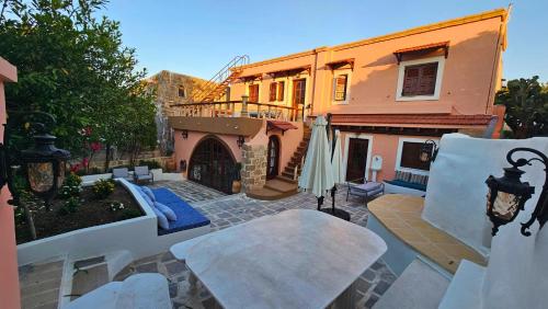 an outdoor patio with chairs and a building at Old Town Pearl in Rhodes Town
