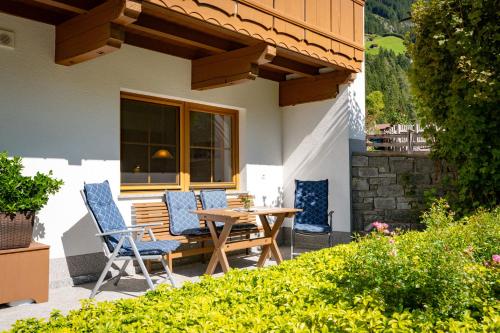 a patio with a wooden table and chairs on a house at Ferienhof Hubertus in Mayrhofen