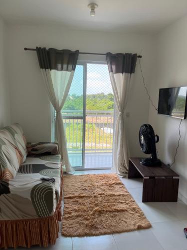 een slaapkamer met een bed en een groot raam bij Apartamento dois quartos com uma suíte in Ananindeua