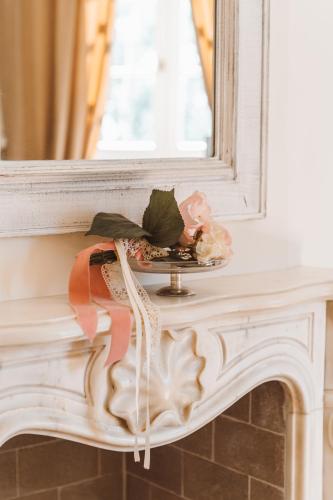 a mantle with a mirror and flowers on it at Villa Nena in Tolentino