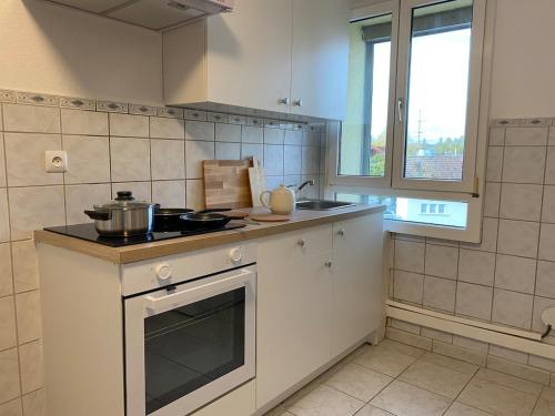 a kitchen with a stove with a pot on it at Maison Tivoli in Huningue