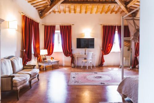 a living room with red curtains and a couch and a desk at Villa Nena in Tolentino