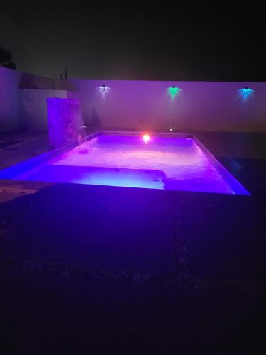 a dark room with a pool with purple lights at La Vecchia Village Spacious Private Pool Area in Guayama