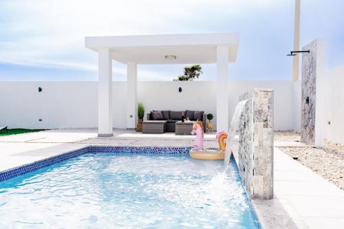 a swimming pool in a villa with a couch at La Vecchia Village Spacious Private Pool Area in Guayama