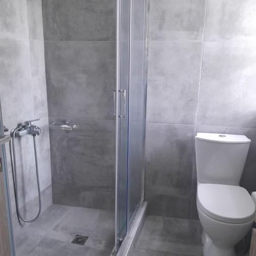 a bathroom with a shower with a toilet and a glass door at Ιχνηλάτες in Agios Nikolaos