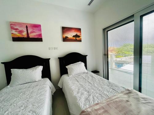 two beds sitting next to each other in a bedroom at Bubali Modern Suites Aruba in Palm-Eagle Beach