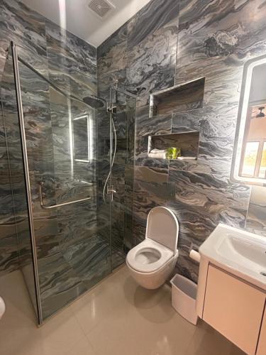 a bathroom with a toilet and a shower at Bubali Modern Suites Aruba in Palm-Eagle Beach