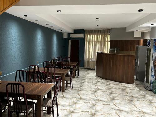 a dining room with tables and chairs and a refrigerator at Ugur Motel Agstafa in Ağstafa