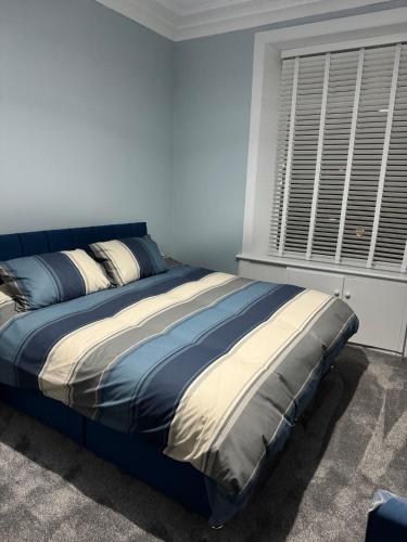 a large bed in a bedroom with a window at Woodside Bungalow in Stevenston