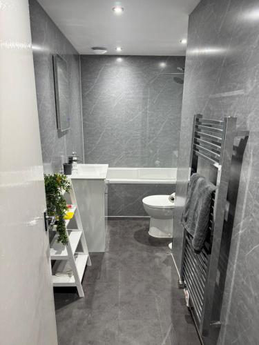 a bathroom with a tub and a toilet and a sink at Woodside Bungalow in Stevenston