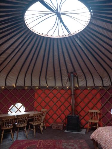 una camera con tavolo e sedie in una yurta di Hillside Retreats a Machynlleth