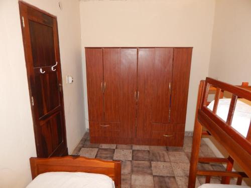 a bedroom with a wooden cabinet and a bunk bed at Cabañas Los Troncos in Ituzaingó
