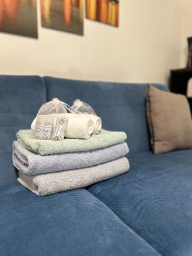 a pile of towels sitting on top of a blue couch at L'Espadon - vue mer, proche plage et gare in Menton