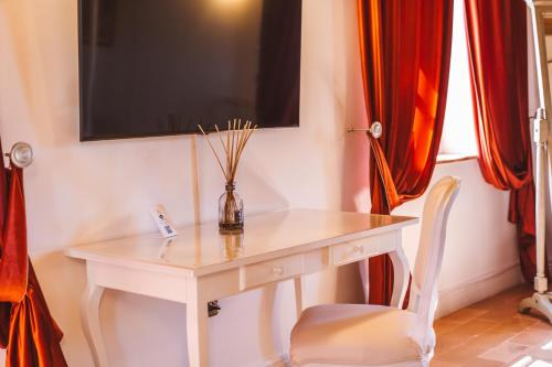 a white table with a vase on it with a chair at Villa Nena in Tolentino