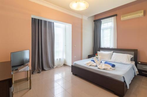 a bedroom with a bed and a flat screen tv at Casa Loma in Triánta