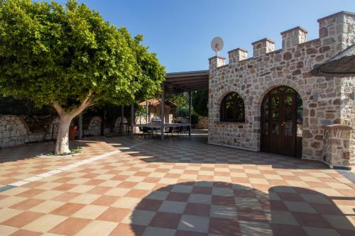 a courtyard with a tree and a stone building at Casa Loma in Triánta