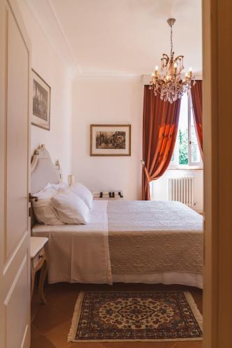 a bedroom with a bed with a chandelier and a window at Villa Nena in Tolentino