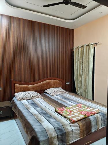 Un dormitorio con una cama grande con ventilador de techo. en Maa Shanti Guest House, en Sehore