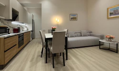 a kitchen and living room with a table and a couch at MK Luxury Serviced Apartments #3 in Chişinău
