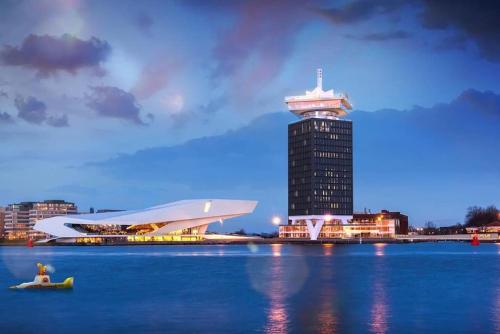a building with a tower in the middle of the water at Bed and breakfast private accommodation at Amsterdam Houseboat in Amsterdam