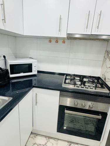a kitchen with a stove and a microwave at Apartamento Noori 1B in Vinarós