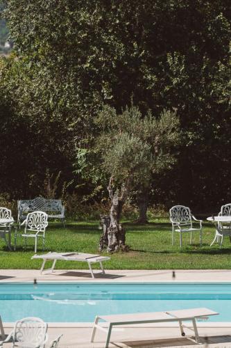 a group of white chairs and a swimming pool at Villa Nena in Tolentino