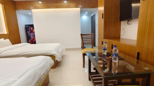a room with two beds and a table with two bottles of water at The Castle Inn in Dhaka