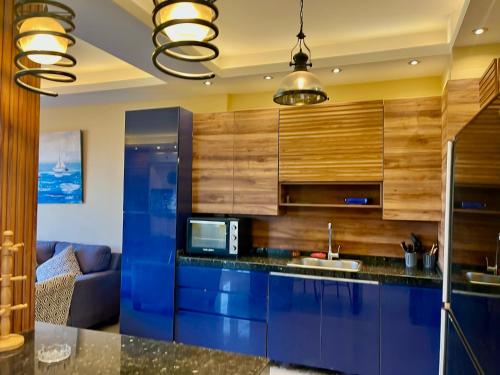 a kitchen with blue cabinets and a blue counter top at 3-Brs Beachside Modern chalet Seaview & 3min walking l BBQ in Ain Sokhna