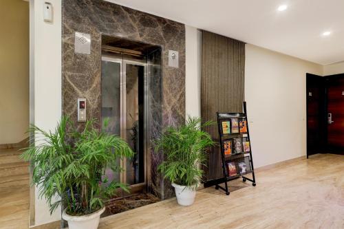 a lobby with two potted plants in front of an elevator at Townhouse Hotel Sec- 54 Golf Course Road in Gurgaon