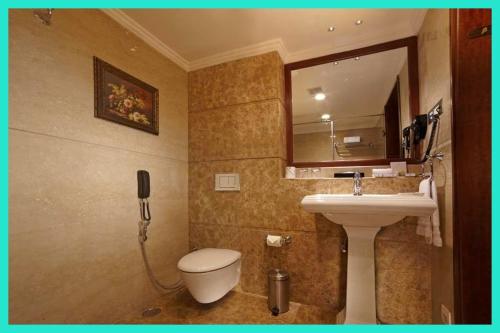 łazienka z toaletą, umywalką i telefonem w obiekcie HOTEL - NEW BEST - M ! MG - ! Varanasi - Free Wi - Fi & Fully Air Conditioned Hotel - Near Kashi Vishwanath Temple !! w mieście Rāmnagar