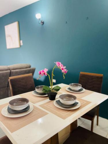 a dining room table with plates and flowers on it at Discover Paradise in Discovery Bay