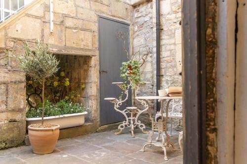 a patio with a table and chairs and plants at Milliners Court - One-Bed Cottage in Central Bath in Bath
