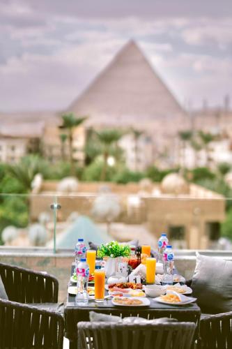 a table with plates of food and drinks on it at pyramids&tuya&view stone in Cairo